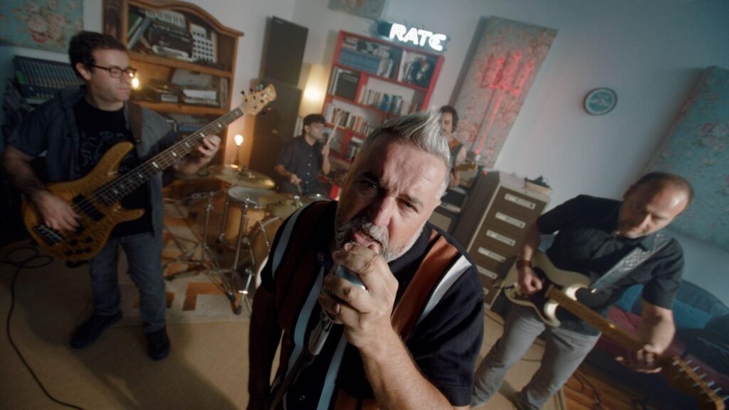La banda Chico Infierno tocando con energía en su local de ensayo, en una fotografía promocional para medios.